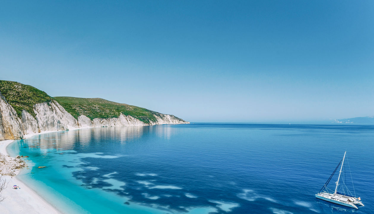 Greek coastline with turquoise sea, white sandy beach and rocky cliffs by the Mediterranean | MSC Cruises