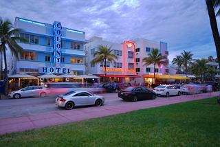 Art deco buildings with neon lights and palm trees along a lively Miami street | MSC Cruises