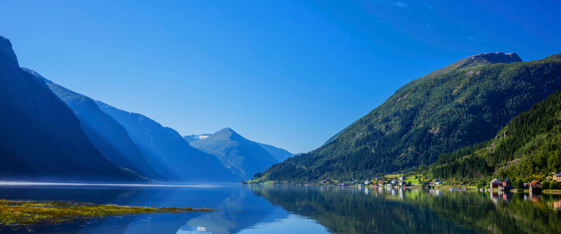 Norwegian fjords and mountains beautifully reflected in calm waters of Northern Europe | MSC Cruises