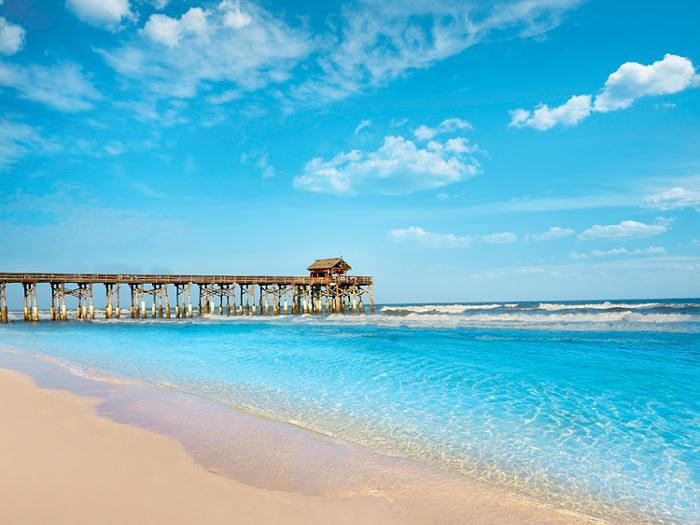 Sandy beach with a long pier and blue sky at Cocoa Beach in the United States | MSC Cruises