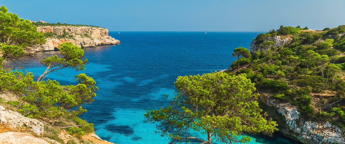 Mediterranean bay with turquoise sea and lush rocky cliffs in Mallorca, Spain | MSC Cruises