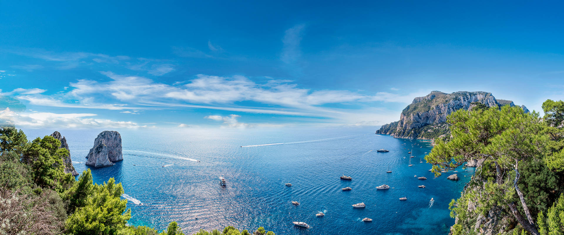 Mediterranean coastline with lush cliffs, blue sea and a boat by Italy’s Capri | MSC Cruises