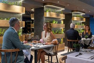 A couple enjoys dinner and wine at Chef's Garden Kitchen specialty restaurant on MSC World Europa | MSC Cruises