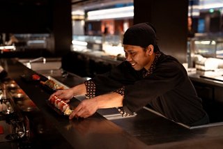 A sushi chef prepares dishes in a contemporary restaurant setting onboard the cruise | MSC Cruises