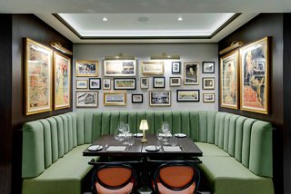 Dining booth with green seating, a table and walls adorned with diverse paintings | MSC Cruises