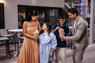 Family shares a meal together at a specialty restaurant on MSC World America | MSC Cruises