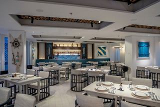 Contemporary restaurant with neatly arranged tables and chairs aboard MSC World Europa | MSC Cruises