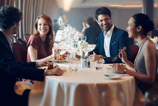 A group of friends share a formal dining experience together in an elegant restaurant | MSC Cruises