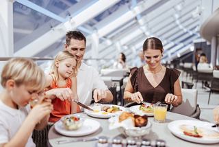 Family enjoys breakfast together in a bright restaurant aboard a cruise ship | MSC Cruises