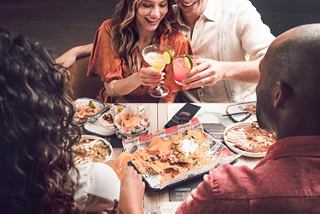 A group of people share diverse dishes and drinks in a welcoming and friendly setting | MSC Cruises