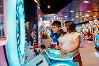 Children enjoy arcade games in a vibrant entertainment area | MSC Cruises