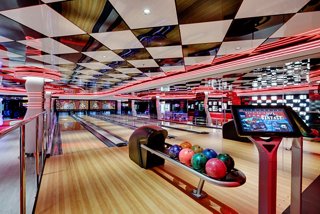 Bowling alley with colorful balls and screens for entertainment onboard MSC Seaside | MSC Cruises