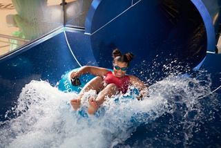 Child rides a waterslide in the aquapark aboard MSC World Europa | MSC Cruises