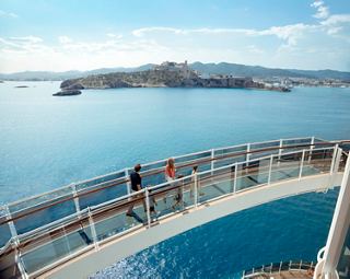 Guests cross the Bridge of Sighs on MSC Seashore overlooking Ibiza and the beautiful coastline | MSC Cruises