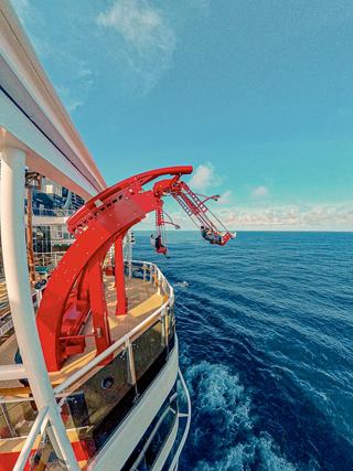 A red thrill ride extends over the blue sea, offering adventure onboard the cruise ship | MSC Cruises