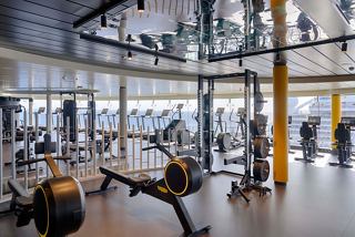 Spacious gym featuring Technogym equipment and panoramic windows overlooking the sea | MSC Cruises