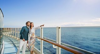 A couple enjoys the sea view from the balustrade aboard MSC Seashore | MSC Cruises