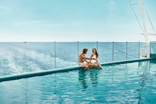 A couple enjoys the infinity pool overlooking the sea and sky | MSC Cruises