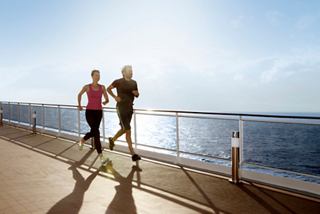 A couple enjoys power walking on the deck’s track with sunrise views over the sea | MSC Cruises