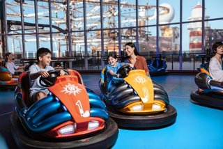Families enjoy bumper cars together in a vibrant and modern sportsplex | MSC Cruises