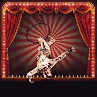 Performer showcases a dynamic dance on stage framed by vibrant red curtains | MSC Cruises