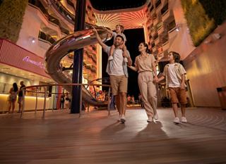 Guests enjoy a lively stroll along the illuminated promenade on the cruise ship | MSC Cruises