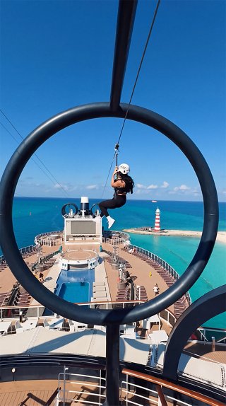 A guest experiences the zip line above the deck with a stunning view of the sea | MSC Cruises