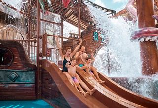 Family enjoying the waterslide at Pirates Cove Aquapark on MSC Seashore | MSC Cruises
