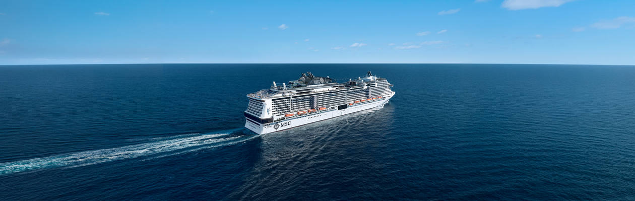 Cruise ship sails across calm blue sea beneath a clear sky | MSC Cruises
