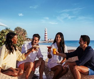 A group of friends enjoy refreshing drinks by the sea on a tropical island | MSC Cruises