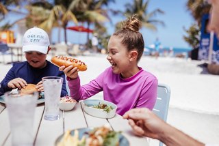 Children enjoying a meal together by the beach at Ocean Cay MSC Marine Reserve | MSC Cruises