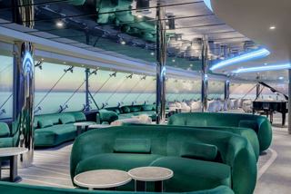 Seating area with green sofas and sea views on MSC Poesia | MSC Cruises