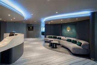 Modern seating area and desk counter in the MSC Yacht Club aboard MSC Poesia | MSC Cruises