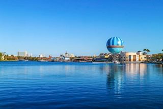 A hot air balloon rises above the lake at Disney Springs surrounded by vibrant buildings | MSC Cruises
