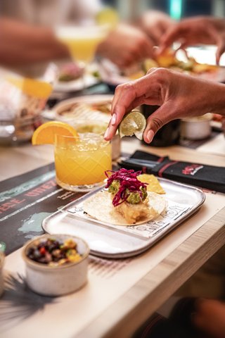 Guests enjoy a variety of dishes and drinks at a restaurant table together | MSC Cruises