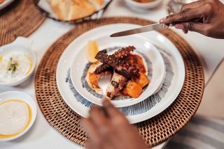Tender octopus and vegetables served on a plate in an inviting dining setting | MSC Cruises