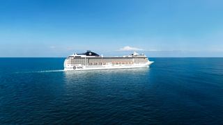 Cruise ship sails across calm blue seas beneath a clear sky | MSC Cruises