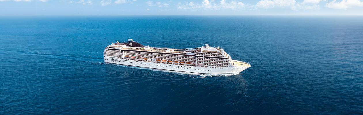 A cruise ship sails across the open blue sea beneath a clear sky | MSC Cruises