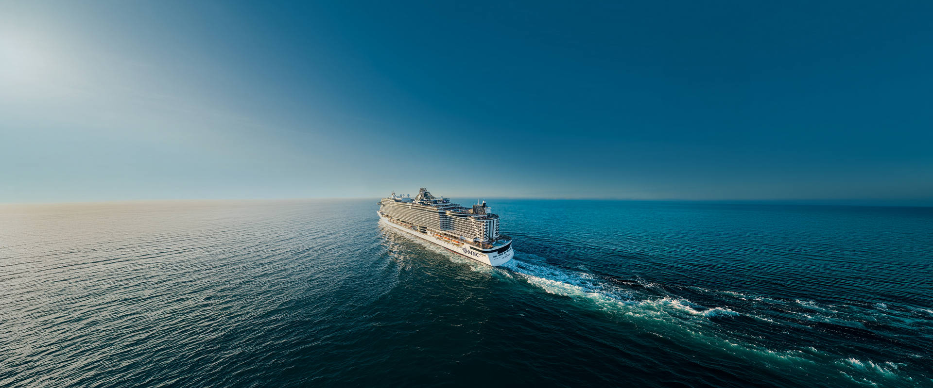 MSC Cruises ship sails across open sea under a brilliant blue sky | MSC Cruises