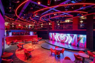 Spacious lounge with stage and vibrant lighting on MSC Seascape | MSC Cruises