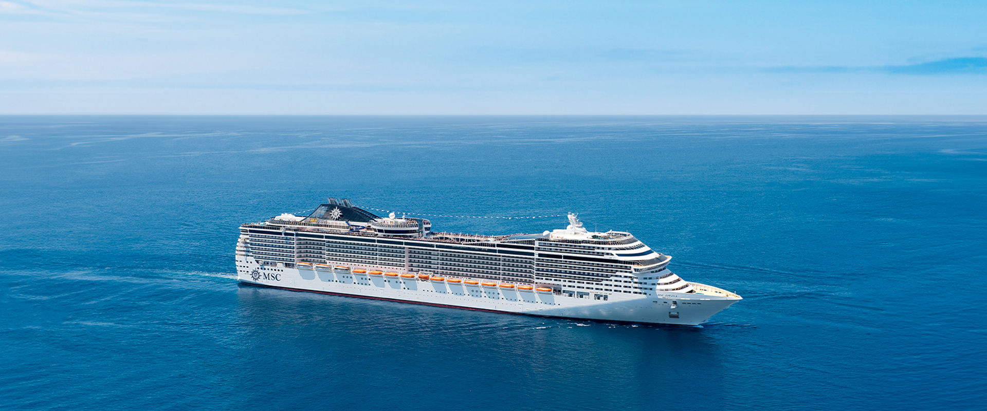 MSC Cruises ship sails across a tranquil blue sea beneath a bright sky | MSC Cruises