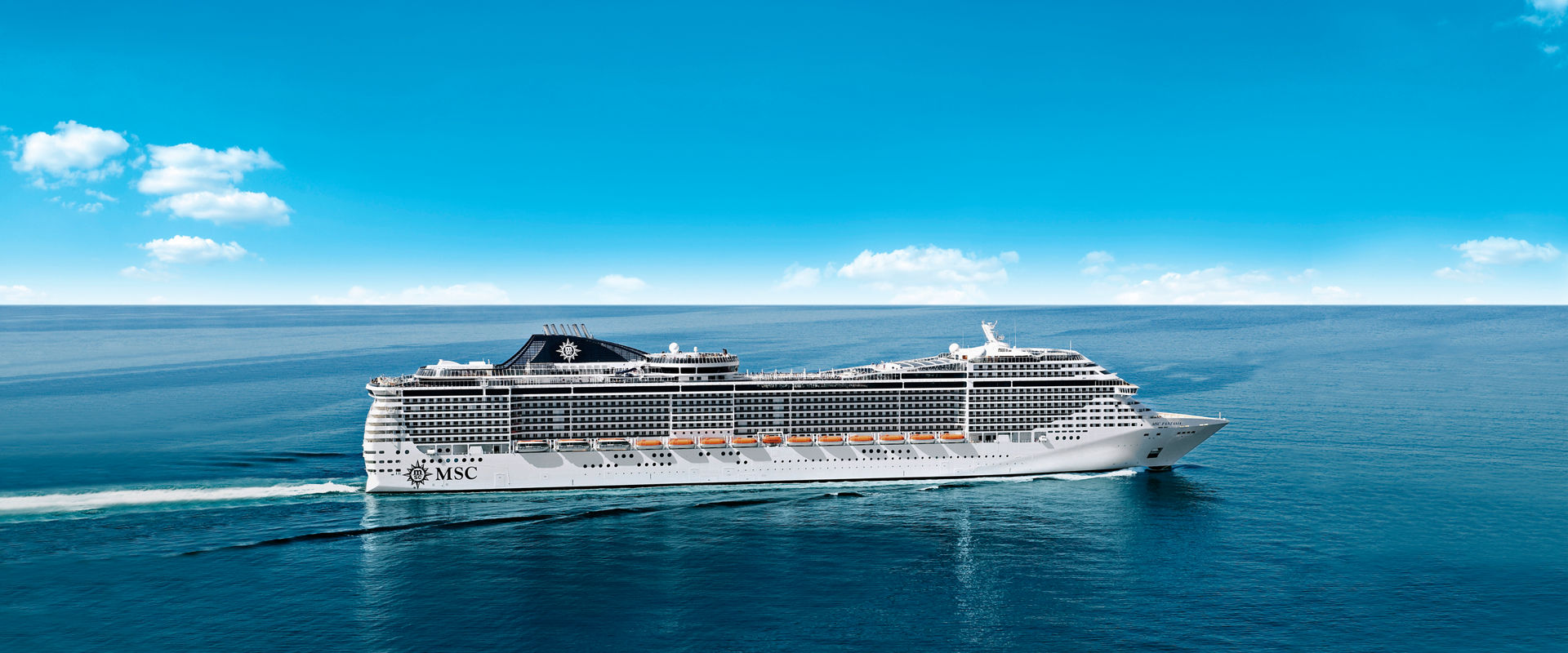 MSC Fantasia cruise ship sails across tranquil sea under a clear blue sky | MSC Cruises