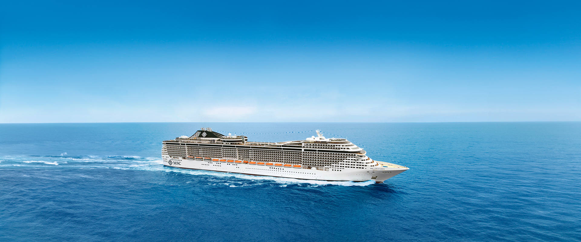 A cruise ship travels across calm blue waters beneath a clear sky | MSC Cruises