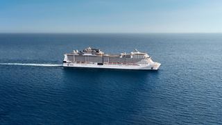 Cruise ship sails across a tranquil blue sea beneath a clear sky | MSC Cruises