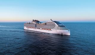 A cruise ship sails across calm waters beneath a clear blue sky | MSC Cruises