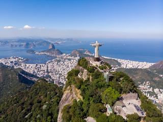 A majestic statue rises above lush hills overlooking the coast of Rio de Janeiro | MSC Cruises