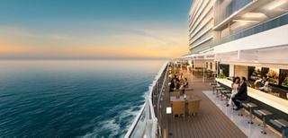 Friends enjoy cocktails together on the deck overlooking the sea at sunset | MSC Cruises