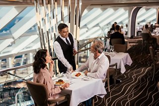 Two guests enjoy dining with sea views and attentive service in a cruise restaurant | MSC Cruises