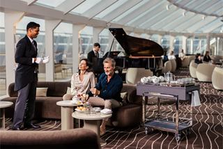Guests enjoy a refined lounge setting with a grand piano and attentive service | MSC Cruises