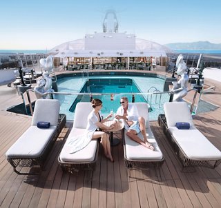 Guests relax on loungers by the pool with a stunning sea view and tranquil atmosphere | MSC Cruises